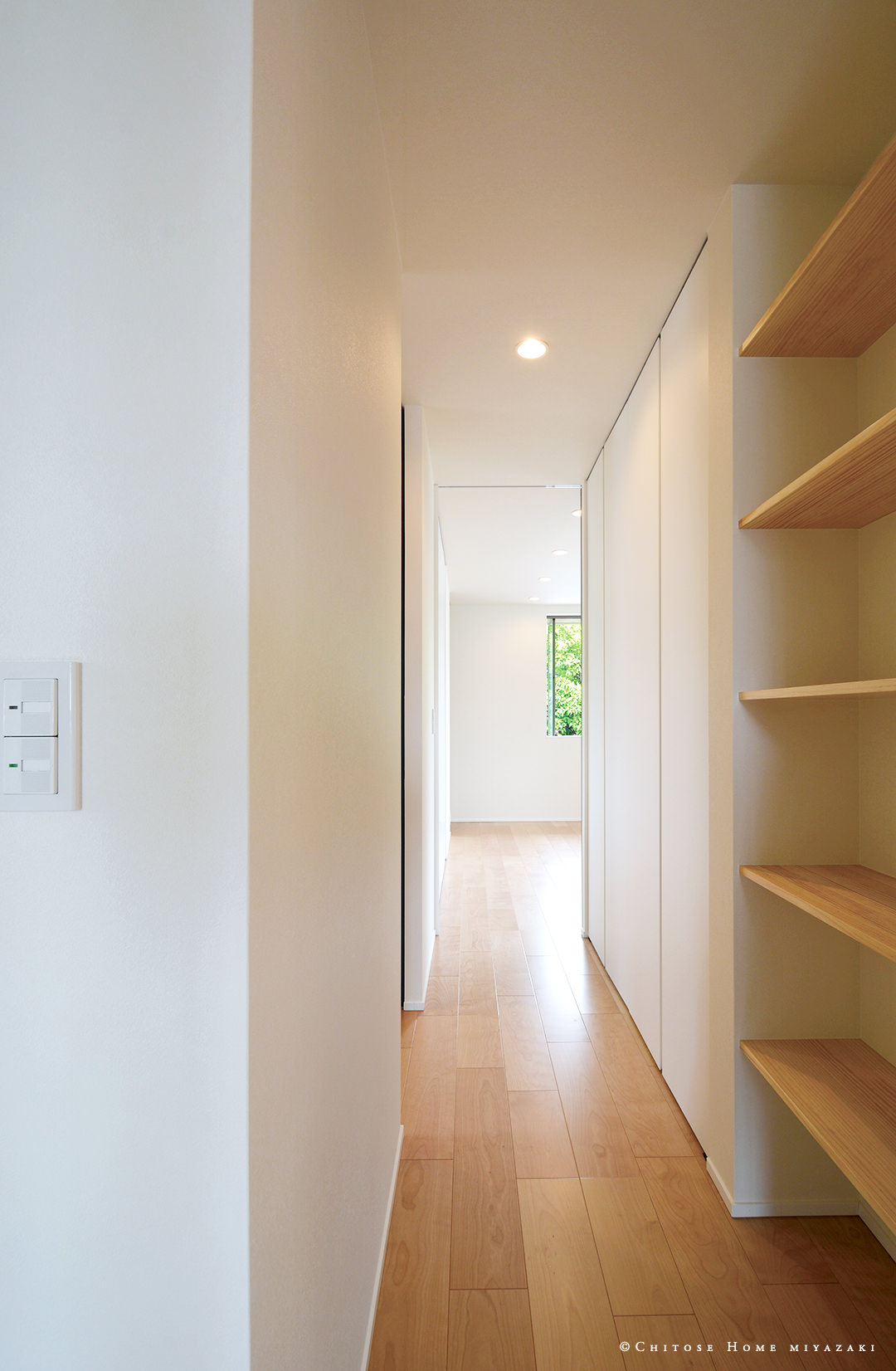 廊下の限られたスペースに収納と本棚を配置。各個室へのアクセスの用途に限らず、リビングから目立たない場所に機能的な収納を配置。使い勝手の実用性を考慮した設計。