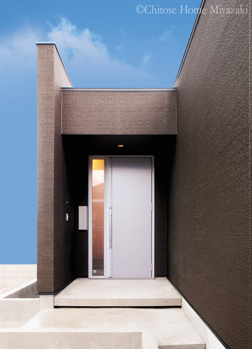 彫りの深いデザインの玄関アプローチ。奥行き感のあるファサードが建物に上質な表情を与える。シンプルでミニマムな素材に建築主の潔い選択を感じさせる。