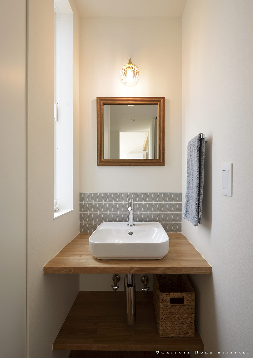 タイルや木製枠の鏡を使った、こなれた雰囲気の手洗いスペース。メインの洗面スペースとは別に、家族のちょっとした手洗いに使いやすいコンパクトな造作を設える。