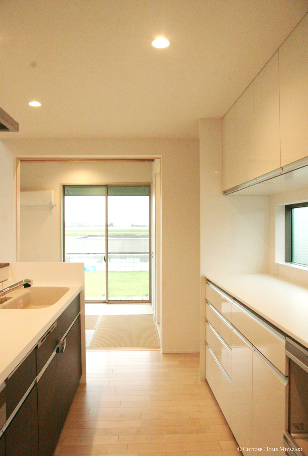 キッチン横の和室の大開口窓から光と風を十分に取り込む。キッチンから洗面、浴室への家事動線に快適な空気の環境を作ることは、日常の生活空間の大切な要素。