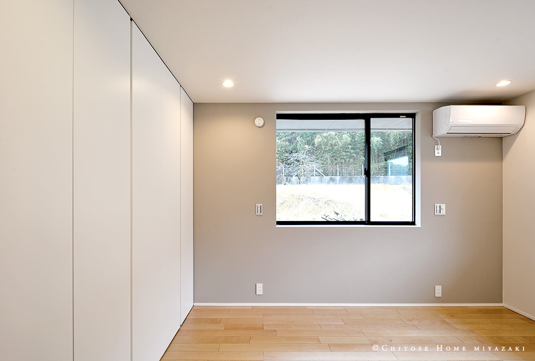 寝室の収納扉は、床から天井までのフルハイト扉を使用。壁のように見せて寝室内をすっきりとした印象に仕上げている。