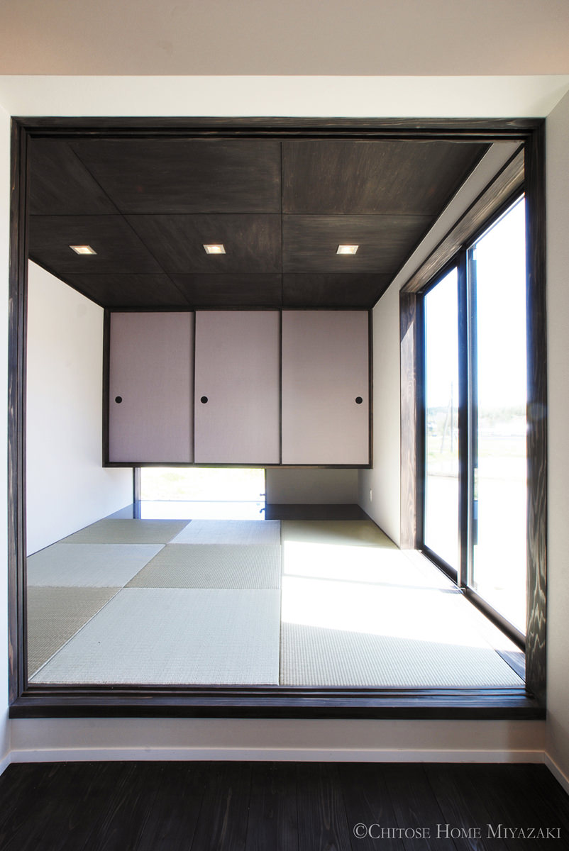 リビングから一段上がった和室空間。琉球タタミと、天井のシナ合板のデザインを揃えて、美しい幾何学模様を魅せるインテリアデザイン。