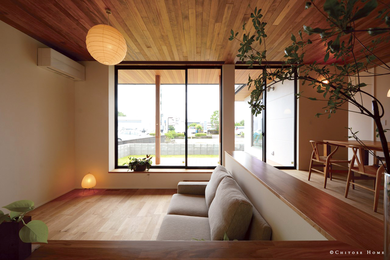 拡がり感あふれるLDKのリビング部分を一段下げて、家族の憩いのスペースに居心地の良さをもたらす仕上げに。飾り棚としての性質を持たせたカウンターで囲い、こもり感のあるリビングに。