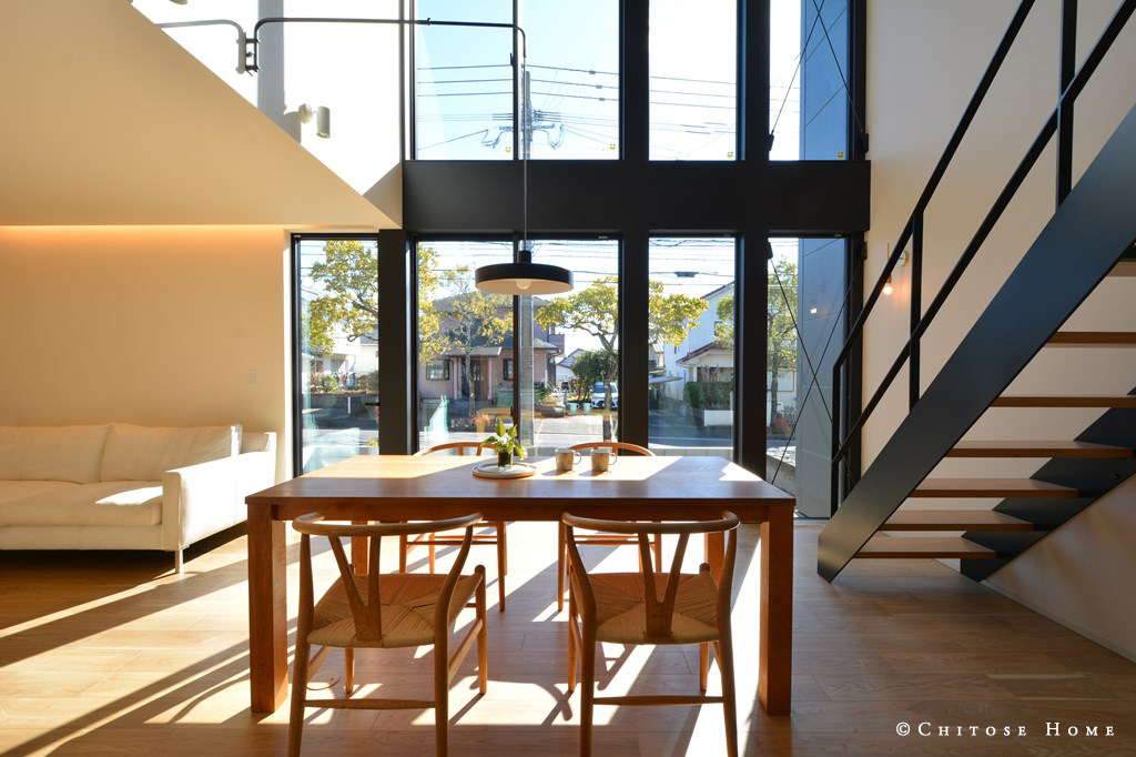 東南方向に位置するダイニング吹き抜けに高さ約５ｍの連続した窓を据える。外観からも内観からも印象的な雰囲気を窓で演出する。華奢でシャープなアイアン製のオープン階段を、インテリアの脇役として添える。