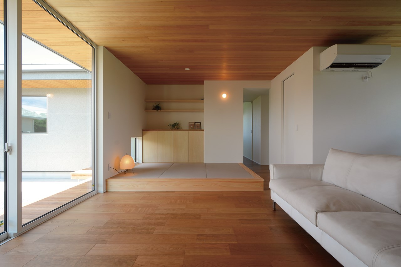 リビングに隣接する小上がりの畳コーナーには、シナ合板による造作収納を設えた。上品で控え目な木目が美しい、さりげない存在感のリビング収納。