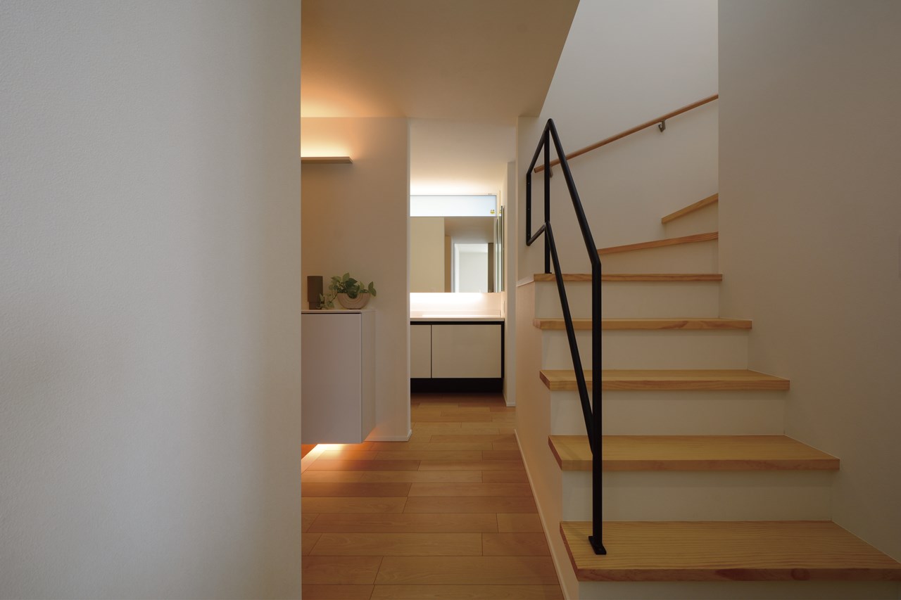 玄関ホールから死角になった奥側に、トイレ・洗面・脱衣室・お風呂を配置。帰宅後の動線の良さと、生活感を感じさせない配置計画の両立を図る。間接照明で靴箱周りの上質感をプラス。