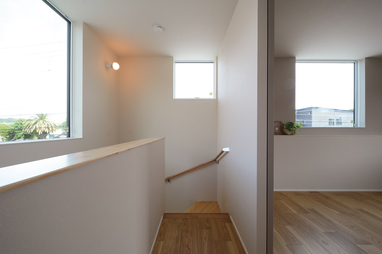 見晴らしの良い北東方向には大きなFIX窓を設えて、柔らかな自然光の採り込みと空間の抜け感を演出。階段ホールの腰壁や窓枠は、薄い仕上げの天板を採用して洗練された空間づくりを。