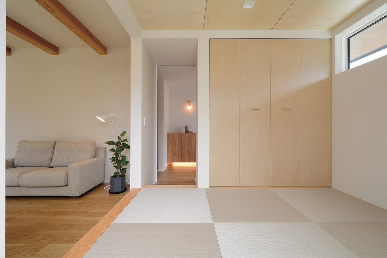 LDKと一体の和室は、将来の使い勝手の変化を見据えて二方向からの出入りが可能な配置に。控え目な木目が印象的なシナ合板仕上げの天井や収納扉、ヘリ無し畳といった部材を使い、LDKのインテリアとの調和を考えたコーディネートに。