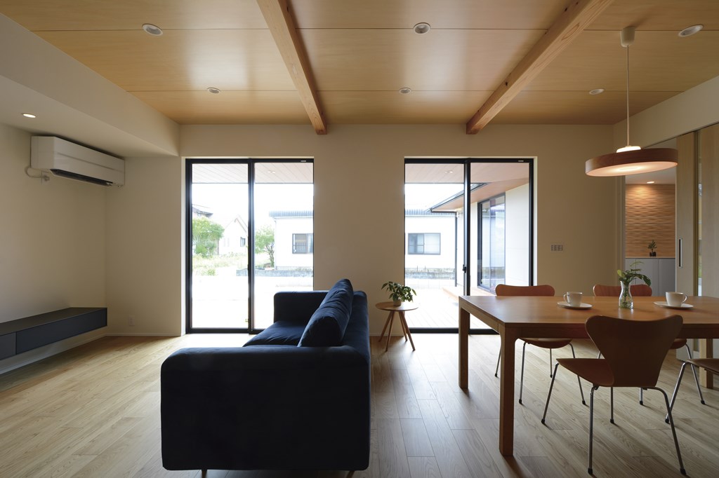 シナ合板による天井板張り仕上げで、控え目で上品な木質感をコーディネートしたLDK。1800㎜の深い軒の出を南面に設け、ウッドデッキと合わせて水平方向への伸びやかな拡がりを演出。