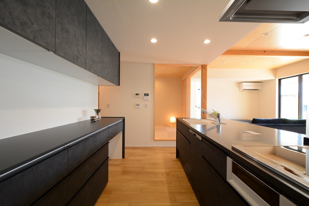 小上がりの和室と隣接するアイランドキッチン。キッチンの裏側には大容量のパントリーへと繋がる動線を確保。