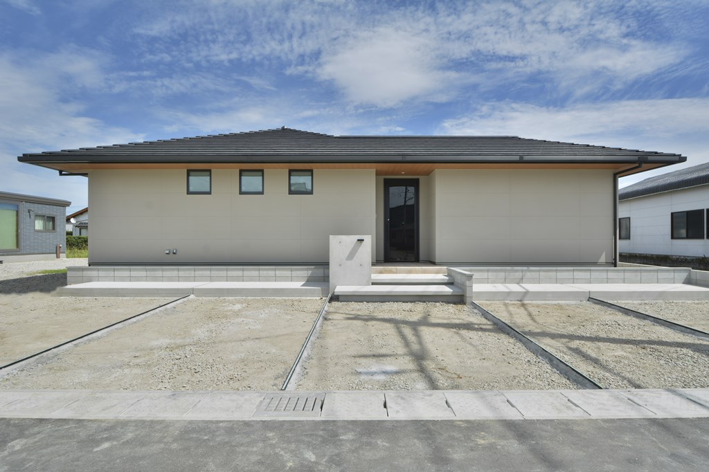 水平ラインを強調した、平板の陶器瓦の屋根仕上げ。凹凸の無いすっきりとしたテクスチャーが印象的な外壁と、木質の軒の出仕上げでコーディネート。