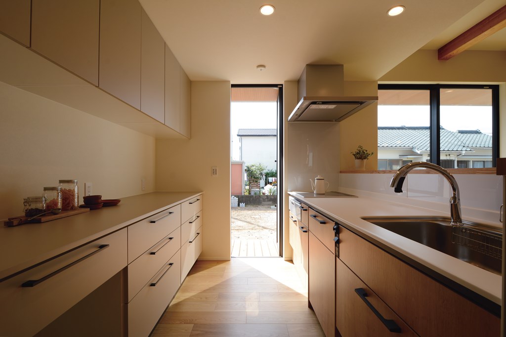 窓や天井高、収納の高さをきれいに揃え、スッキリとした構成で美しい納まりを実現。キッチンからもデッキ越しに庭と行き来できる動線は、普段使いと休日の過ごし方の両面でご家族の使いやすさを支える。
