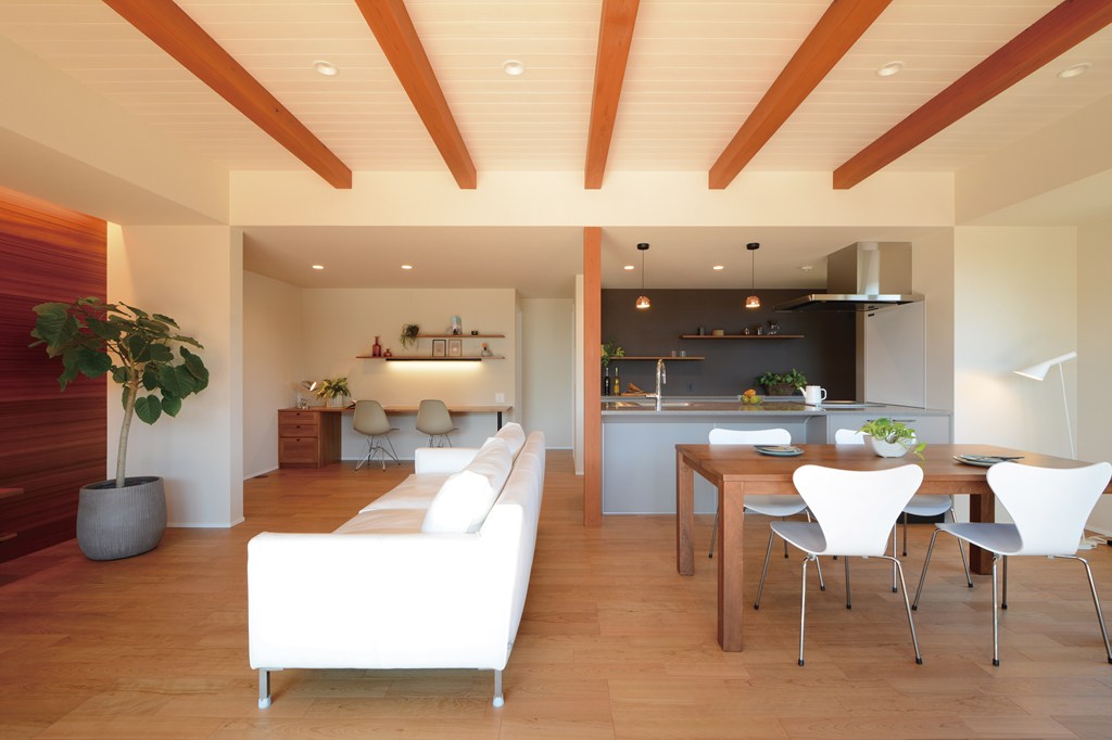 多目的スペースを一角に設けた、広々とした２８帖のLDK空間。奥にパントリー収納を併せ持つアイランドキッチンからは、明るい南側に向かって全体を見渡せる構成でまとめた。