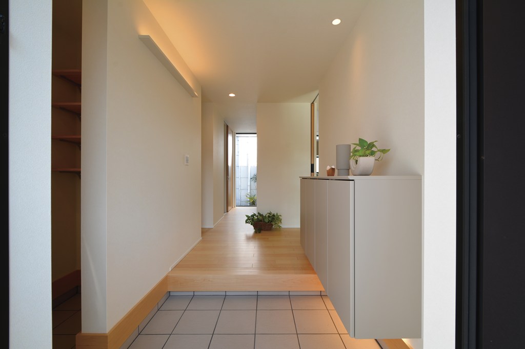 シューズクロークを設えた玄関ホールの正面には、キッチンから外に出入りが可能な扉を設けました。実用性もさることながら、玄関ホールの抜け感を演出し、拡がりを感じやすい構成に。